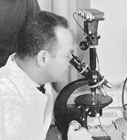Dr. Sreebny looking through microscope in 1959 Yearbook